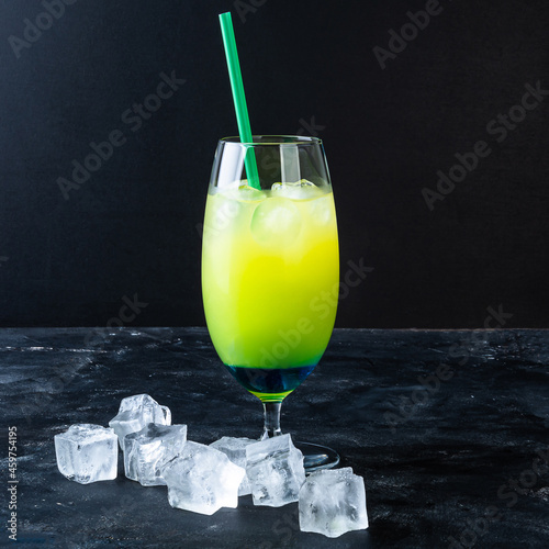 Blue and green cold drink with blue liqueur, soda, with citrus zest