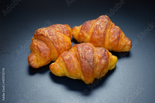 fresh French croissants on dark board, top view