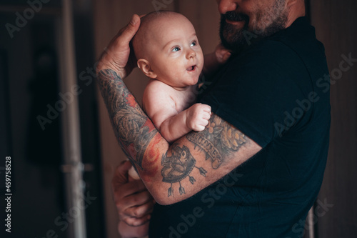 Tattooed bearded father playing with his son