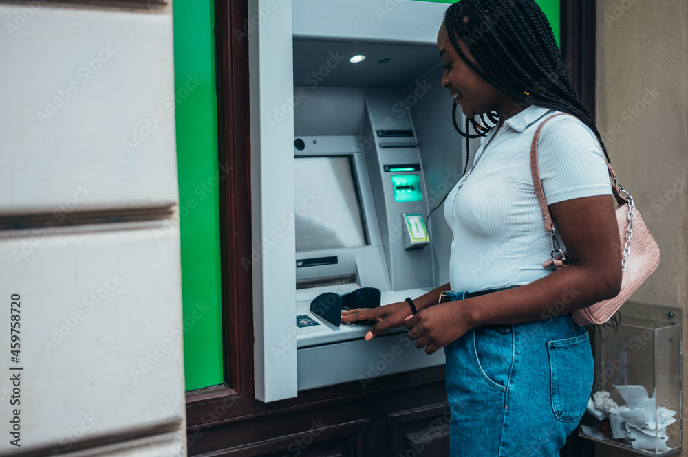African american woman using credit card and atm machine