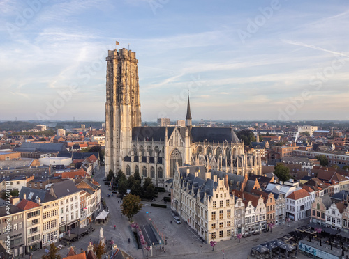 Aerial drone shot of Mechelen Saint Rumbold s Cathedral Sint Rombouts toren in a lovely morning light while birds are flying around