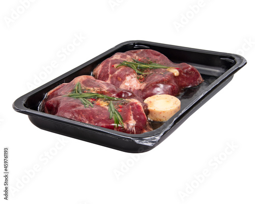 Fresh meat pork steak with garlic, rosemary in vacuum black pack isolated on the white background