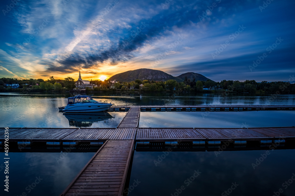 Mont St-Hilaire at sunrise seen from the public marina of Beloeil, with the reflection on the Richelieu River