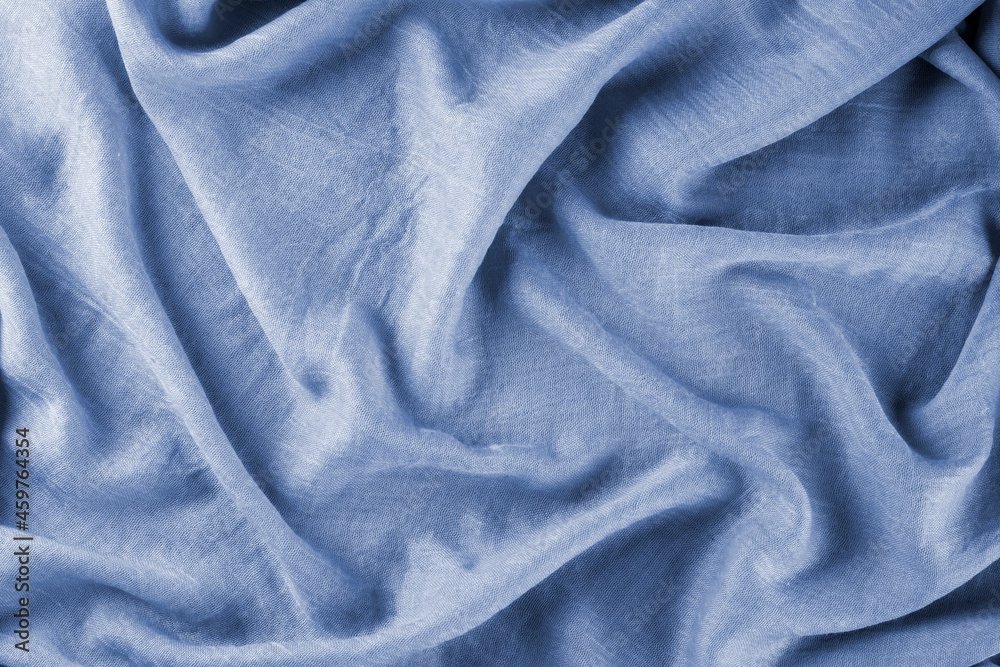 Fototapeta premium Close-up of bright yellow draped lightweight fabric as background. Selective focus.