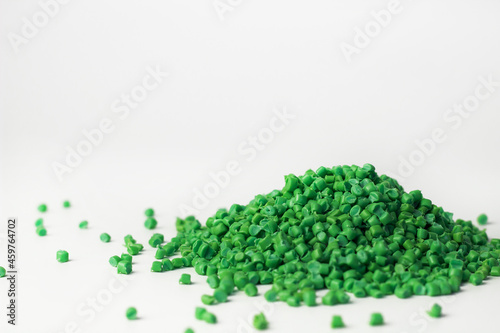 Green granules of polypropylene or polyamide on a white background. Plastics and polymers industry. Copy space. photo