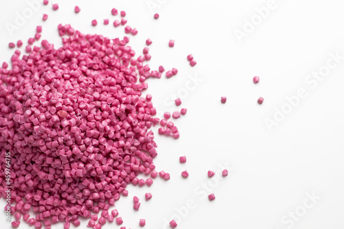 Pink granules of polypropylene or polyamide on a white background. Plastics and polymers industry. Copy space.