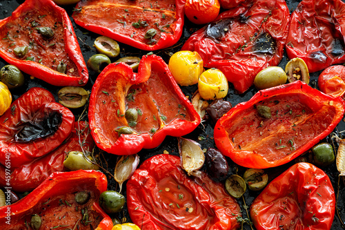 Roasted red pepper with capers, olives and herbs, close up view photo