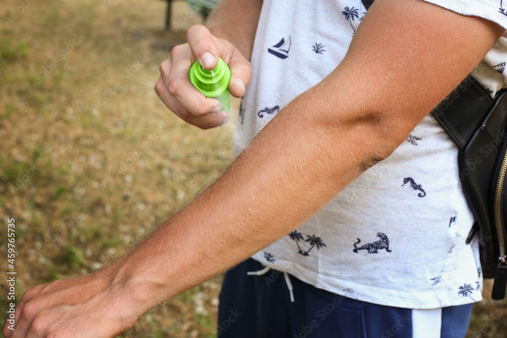 Mosquito repellent. Men using insect spray outdoors, insect bites