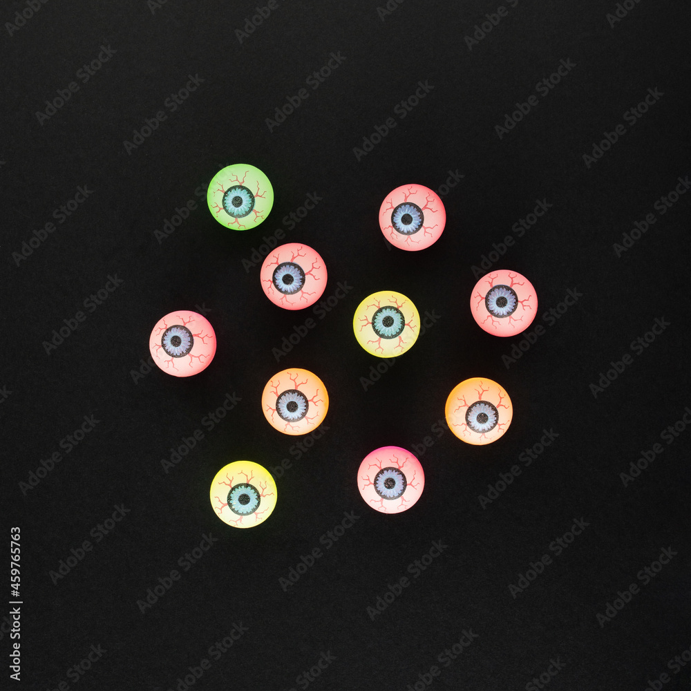 Bloody glowing up  eyes of different colors on a black background. Minimal Halloween concept