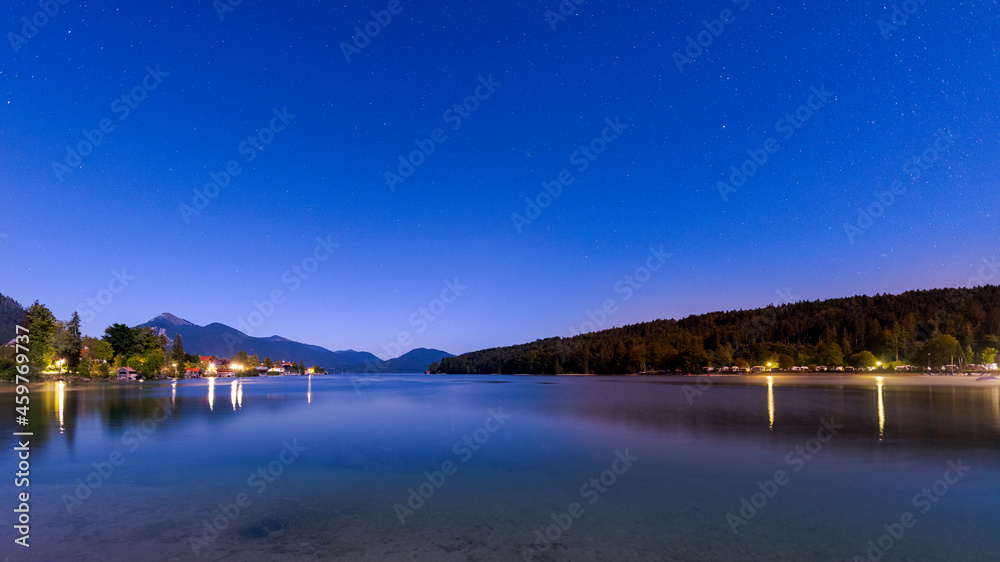 Mountain lake Walchensee in Bavaria, Germany at night with stars in sky