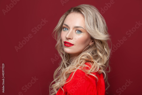 Happy blonde mature woman face on bright red background portrait