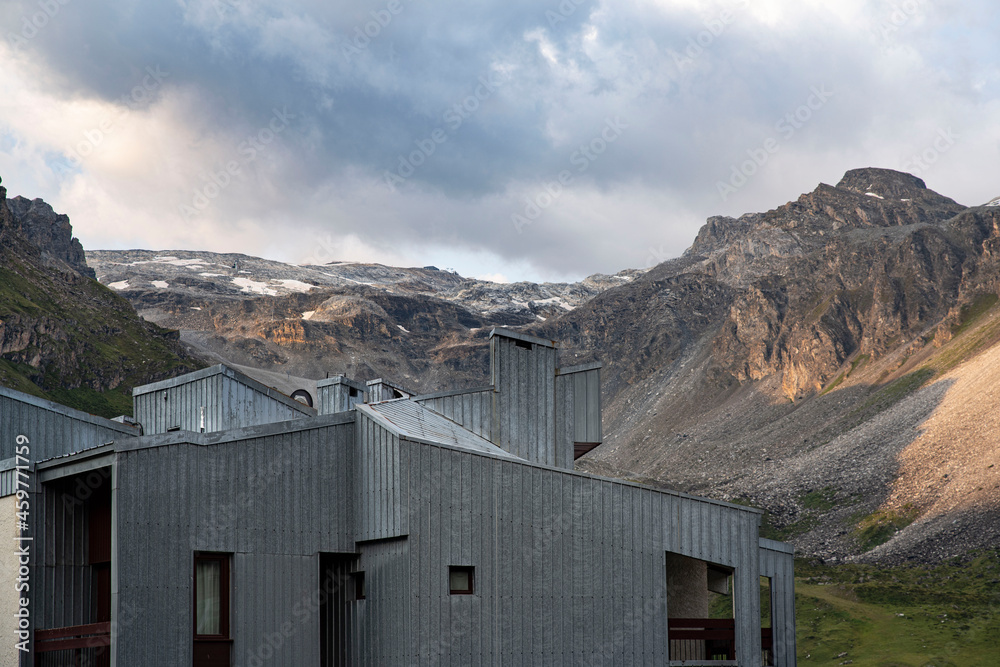 Residential building in front of a mountain with a glacier in summer Residential building in front of a mountain with a glacier in summer
