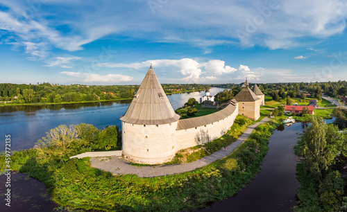 Aerial panoramic view of famous medieval fortress in Staraya Ladoga at sunset. Ancient Russian historical fort on Volkhov River on a sunny summer day. Europe, Russia, Leningrad region, St. Petersburg. photo