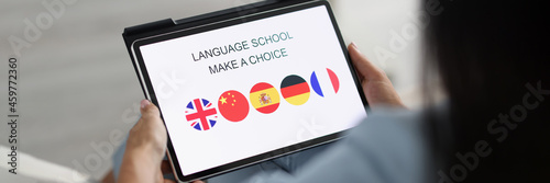 Fotografía Woman holds tablet and chooses a foreign language to study