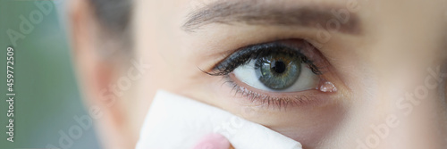 Fotografie Young woman wipes face with cleaning napkin closeup