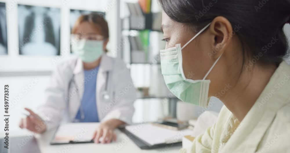 Young Asia lady doctor wear protective mask using laptop is delivering great news talk discuss results or symptoms with girl patient in hospital office. Lifestyle new normal after corona virus. Young Asia lady doctor wear protective mask using laptop is delivering great news talk discuss results or symptoms with girl patient in hospital office. Lifestyle new normal after corona virus.