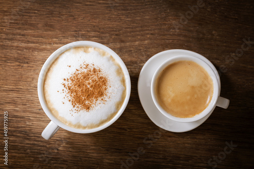 cup of cappuccino and cup of espresso on a wooden background