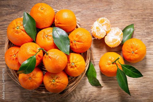 Bowl of fresh mandarin oranges fruit or tangerines on a wooden background
