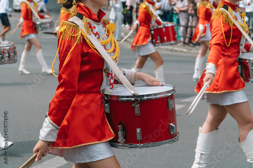 Street performance. Close-up of female drummers hands in red vintage uniform at the parade