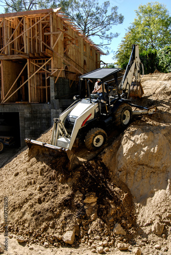 Φωτογραφία Backhoe driving down a steep embankment