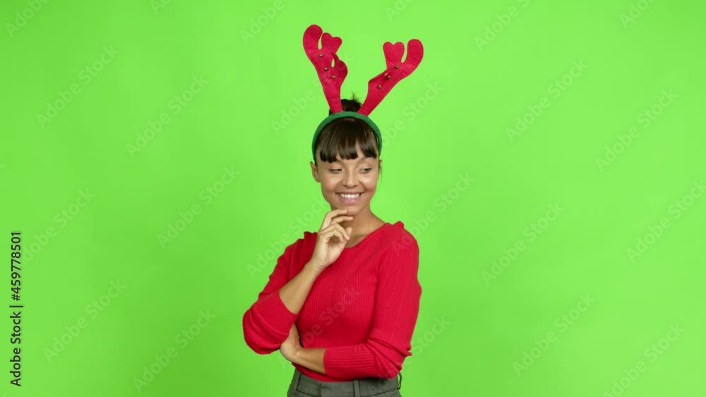 Young woman wearing christmas hat standing and looking to the side over isolated background. Green screen chroma key Young woman wearing christmas hat standing and looking to the side over isolated background. Green screen chroma key