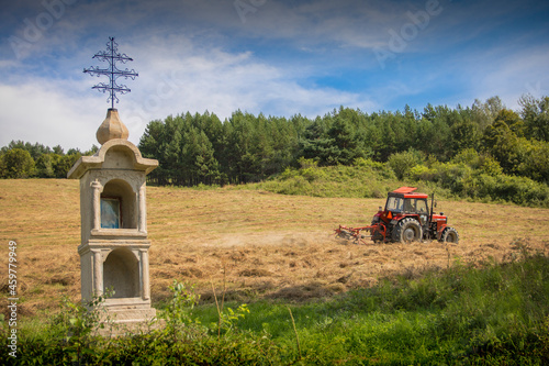 Little Chapel and red tractor located in Podkarpacie Poland (Beskid Niski Mountains) 