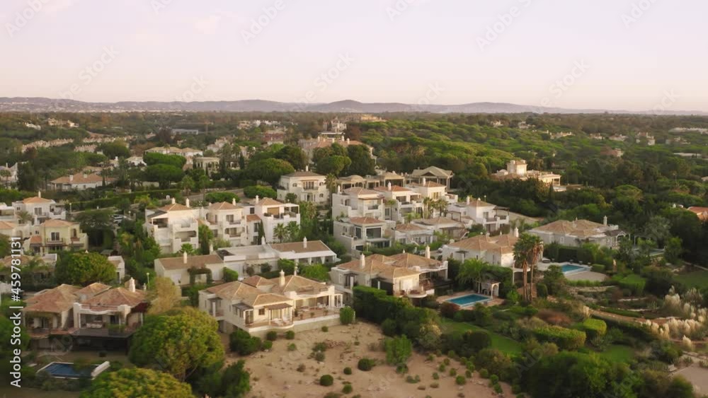 Overview of luxury hotels located around Quinta do Lago, Algarve, Portugal, Europe. Drone shot of private houses situated in green area with mountains on background , 4k footage Overview of luxury hotels located around Quinta do Lago, Algarve, Portugal, Europe. Drone shot of private houses situated in green area with mountains on background , 4k footage