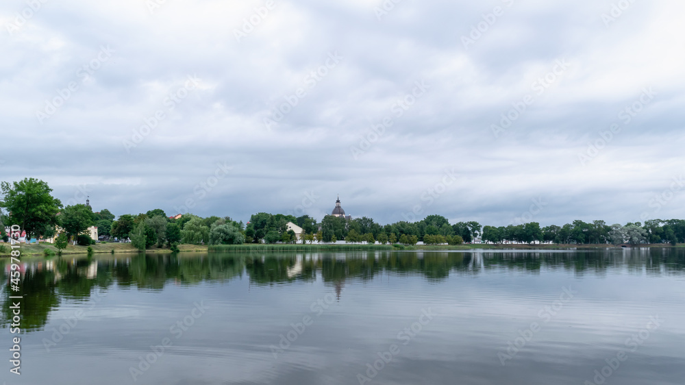 Beautiful summer landscape with architectural elements.Lake overlooking the old Farny Church in Nesvizh, Belarus. Beautiful summer landscape with architectural elements.Lake overlooking the old Farny Church in Nesvizh, Belarus.