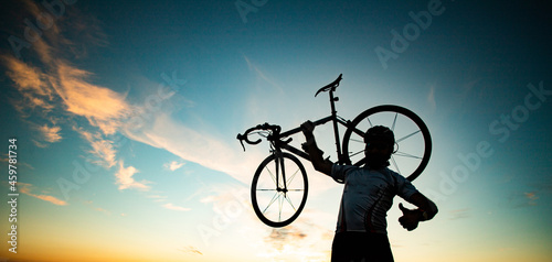 Fototapeta Naklejka Na Ścianę i Meble -  cyclist silhoutte with bicycle raised to sky race and victory concept