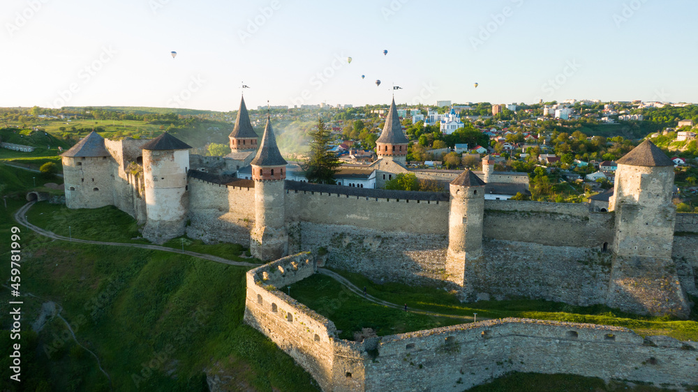 Castle in scenic rural landscape in Ukraine, with hot air balloons on background