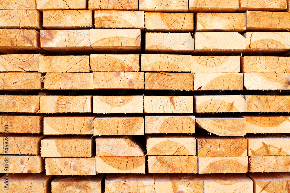 Obraz premium Background from wooden boards close-up. The surface of the end of the board. Stacked timber, lumber, woodworking