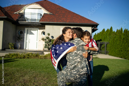 Photography Soldier in uniform coming home and his lovely family with American flag running into his arms celebrating reunion
