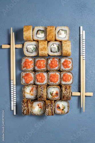 Traditional Japanese food - sushi, rolls and sauce on a dark background. Top view. Blue background