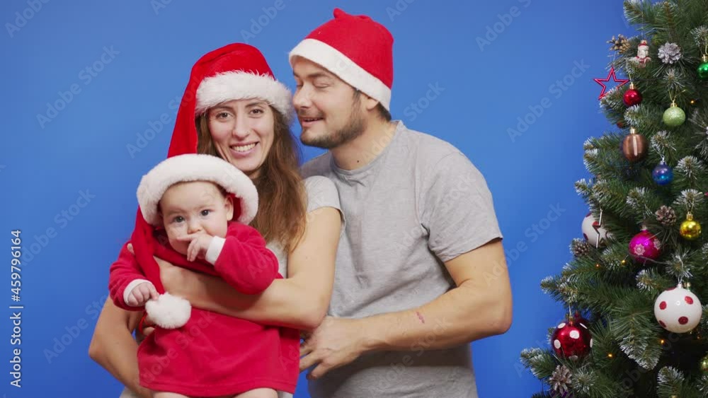 Young Happy Family near Christmas Tree Smiling Waving Hi Making Selfie or Video Message Concept of Family Holidays and New Year. Young Happy Family near Christmas Tree Smiling Waving Hi Making Selfie or Video Message Concept of Family Holidays and New Year.