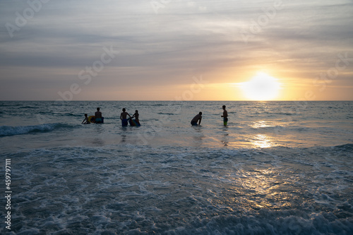 Fototapeta Naklejka Na Ścianę i Meble -  Silhouette of people on the beach at sunset.