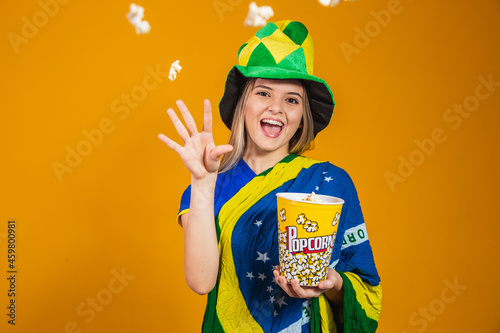 brazilian fan with popcorn to watch the game. Entertainment, sport and patriotism concept