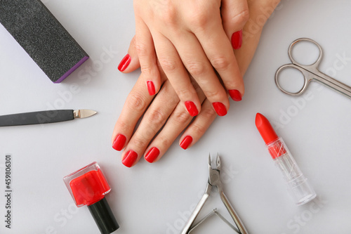 Female hands  tools for manicure  nail polish and lipstick on light background  closeup
