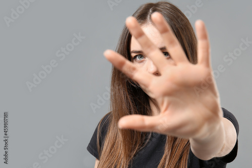 Young woman showing STOP ge...
