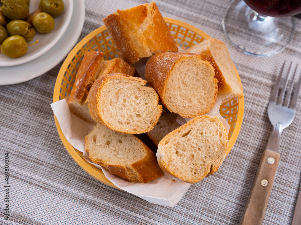 Bread sliced and served on table with green olives