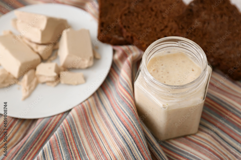 Glass jar with sourdough on table