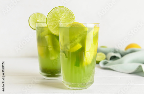 Glasses with tasty lemonade on light wooden background