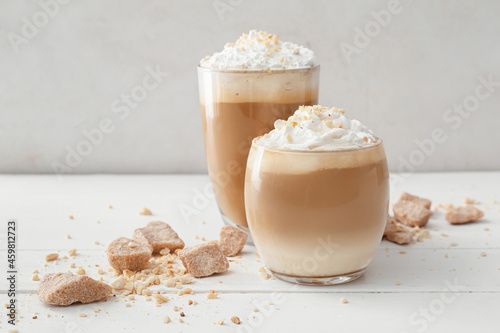 Glasses of tasty latte with nuts on table photo