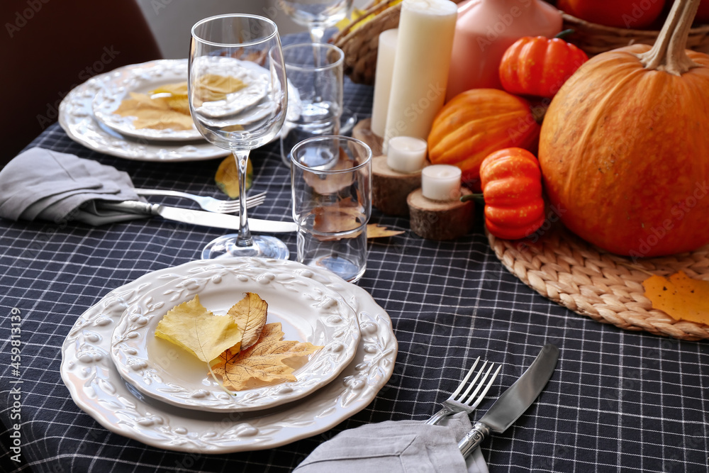Autumn table setting with fresh pumpkins and leaves, closeup