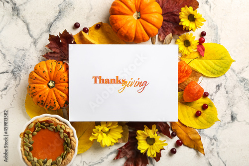 Autumn composition with pumpkins  pie and text THANKSGIVING on light background