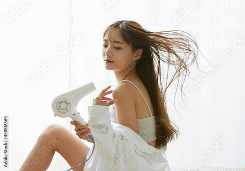 髪の毛を乾かす若い女性 photo