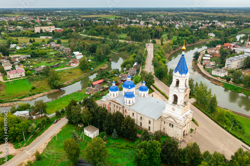 Aerial view of historic Russian town of Kashin on banks of Kashinka River overlooking ancient Resurrection Cathedral with high bell tower on summer day, Tver region