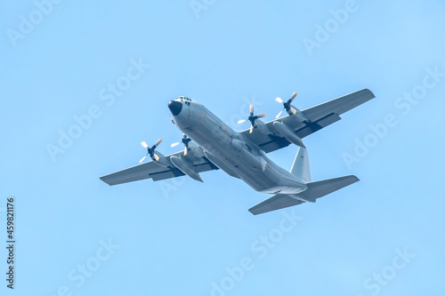 Military transport aircraft conducting training flight in the blue sky background.