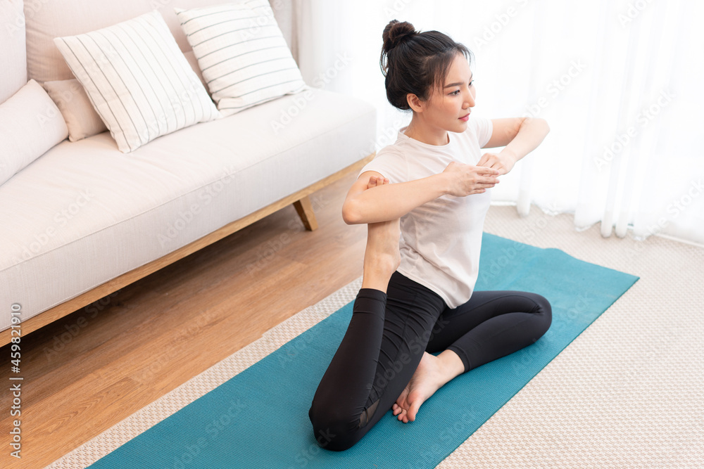 Productive activity concept a girl with a bun wearing the white t-shirt doing the difficult pilates move Productive activity concept a girl with a bun wearing the white t-shirt doing the difficult pilates move