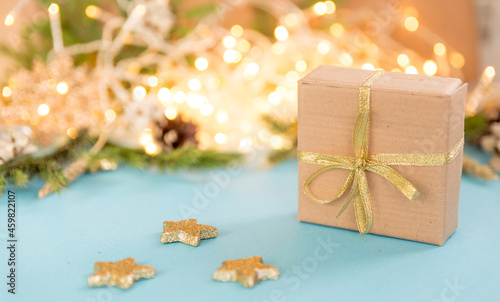 Christmas gift box on a background of glowing garlands. sky blue background with Christmas toys. New year's background with fir branches.