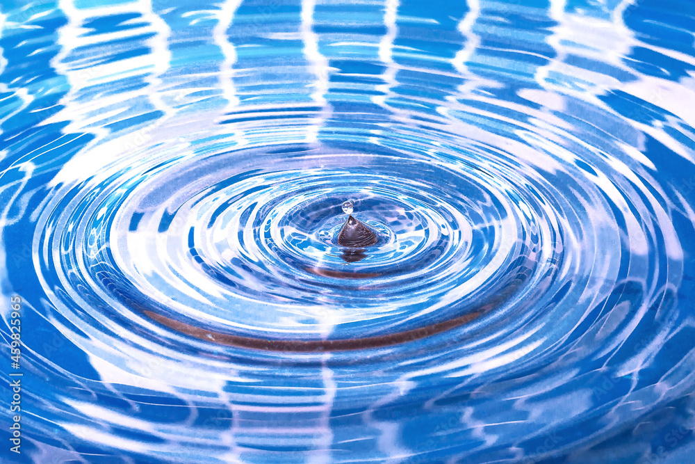 Water splash. Falling drop of water in the pool. Circles on the water.